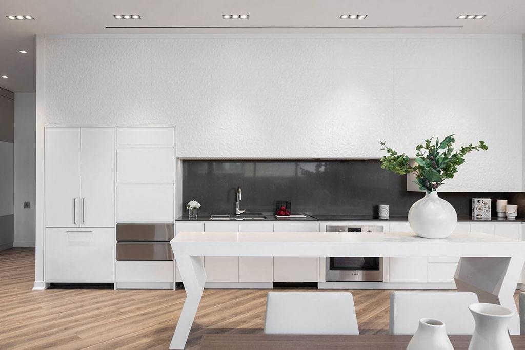 a white kitchen with a white table and white chairs
