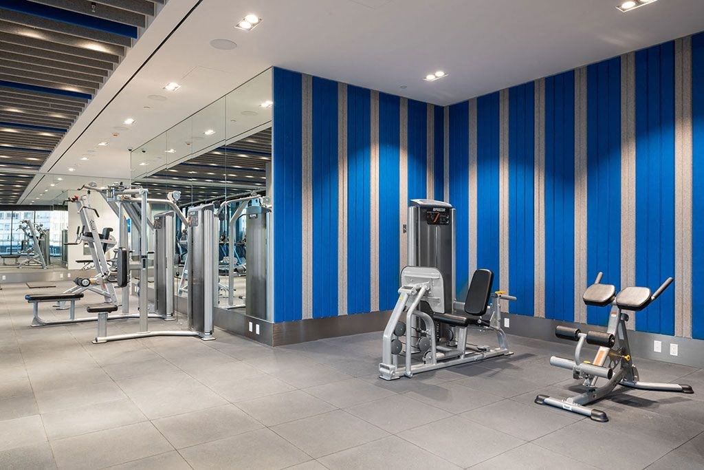 a gym with exercise equipment and blue striped walls