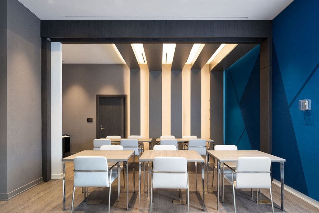 a conference room with tables and chairs and a blue wall