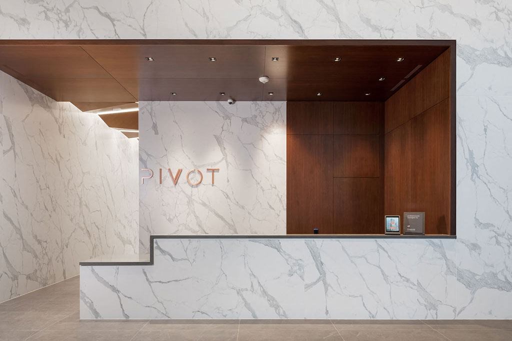 the lobby of a hotel with a marble reception desk