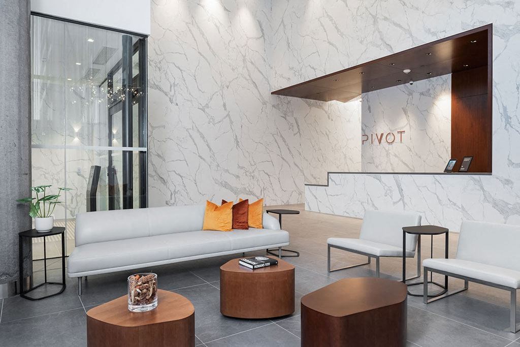 a lobby of a hotel with a couch and tables