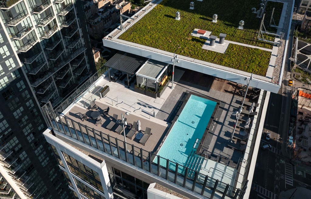 an aerial view of a pool on top of a building with a green roof