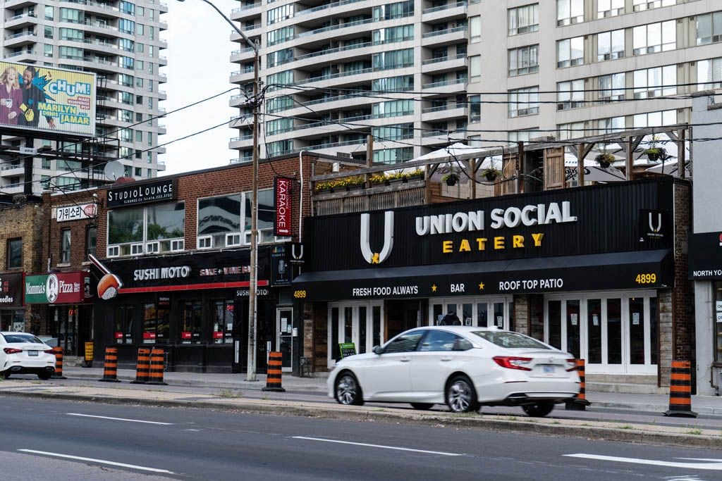 a car driving down a street in front of a restaurant