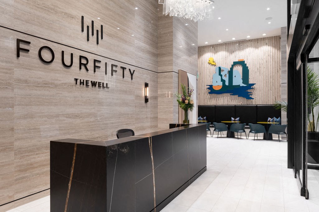 the lobby of a hotel with shadows on the wall and a reception desk