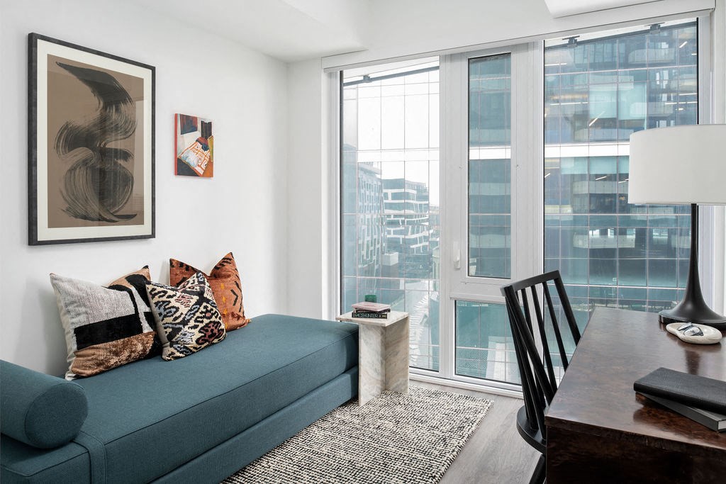 a living room with a blue couch and a table with a large window