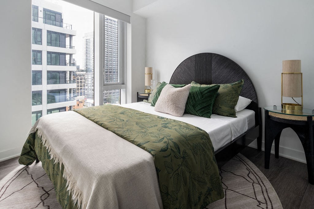 a bedroom with a bed and a large window