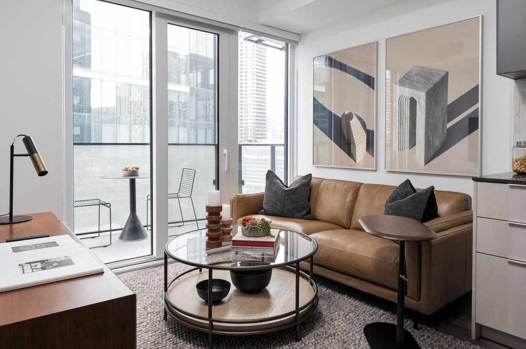 a living room with a leather couch and a glass coffee table
