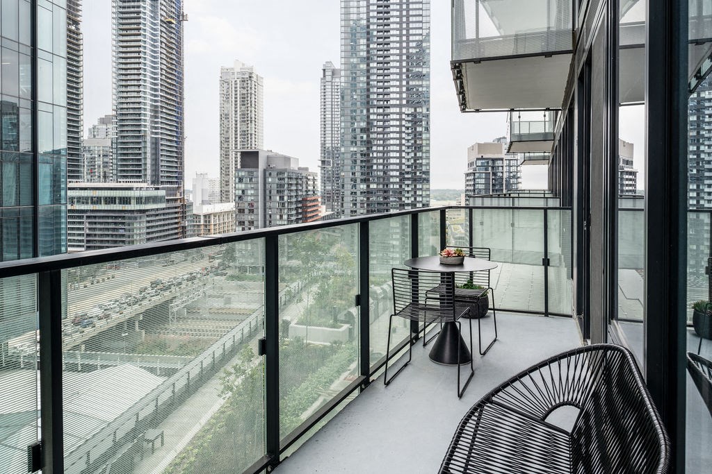 a balcony with a view of a city and a table and chairs