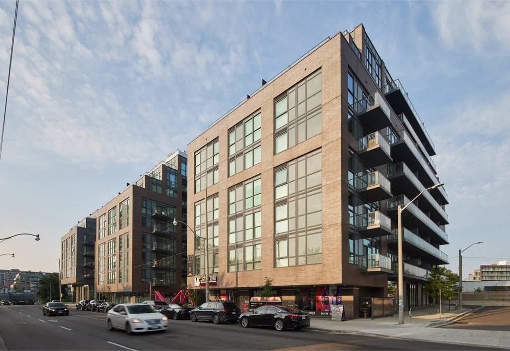 a large brick building with many windows and a parking lot in front of it