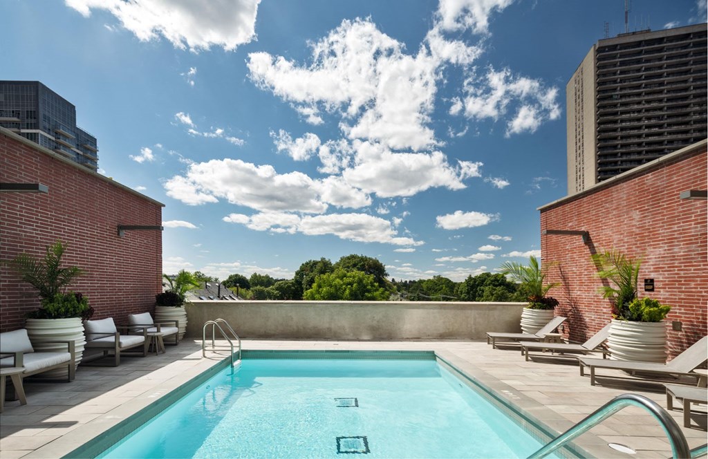 Amenities- a swimming pool on the rooftop of a building with a blue sky