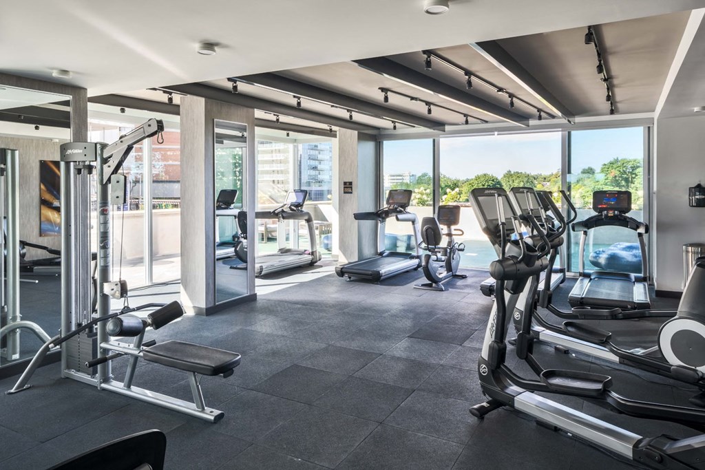 a gym with cardio equipment and a view of a pool