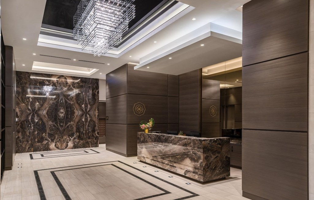 a lobby of a hotel with a marble reception desk