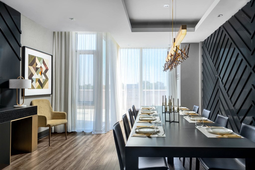 a dining room with a long black table and chairs