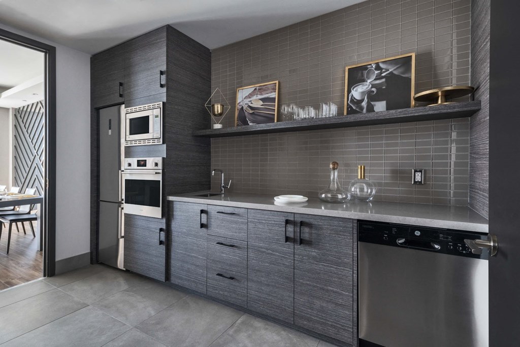 a kitchen with gray cabinets and stainless steel appliances