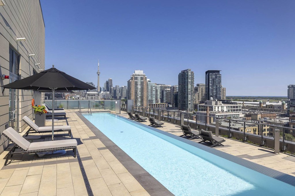 the pool on the rooftop of a building with a view of the city