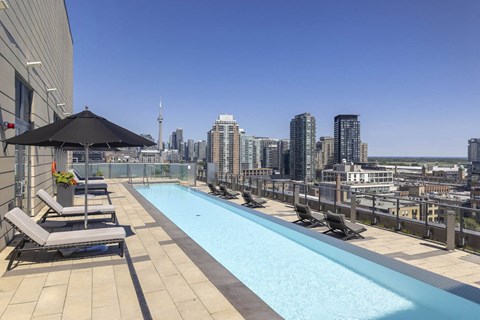 the pool on the rooftop of a building with a view of the city
