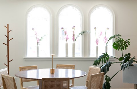 A dining room with a round table and chairs.