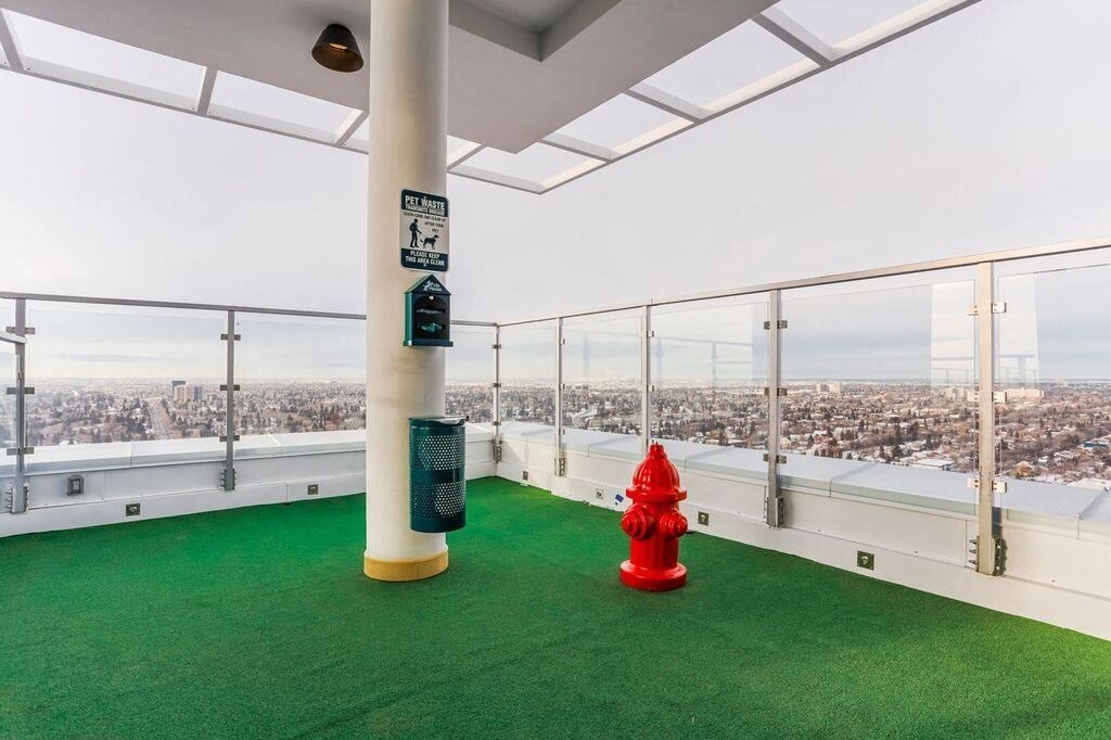 a red fire hydrant on a balcony with a view of the city