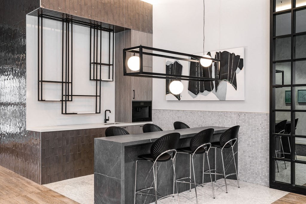 a kitchen with a marble counter top and chairs