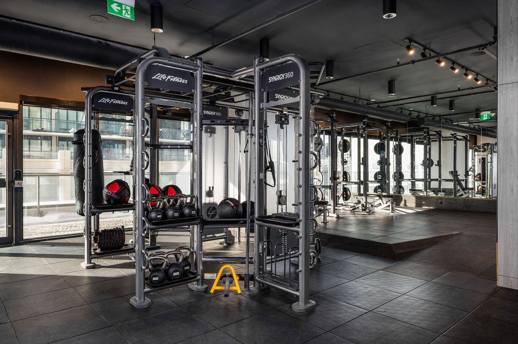 a workout area with weights and cardio equipment in a gym