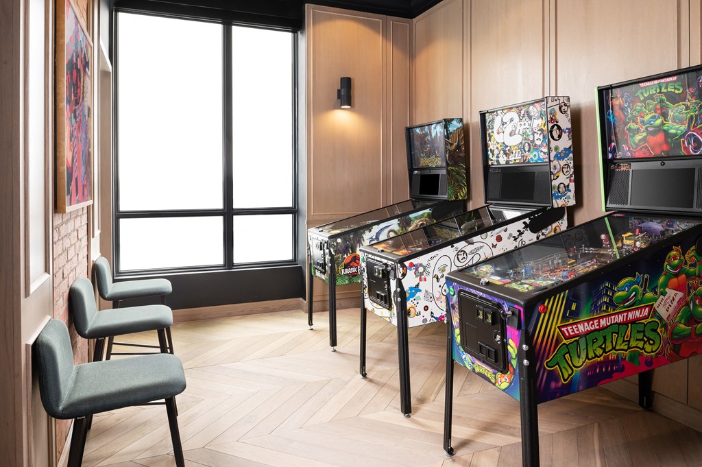 a room with a row of arcade games and chairs