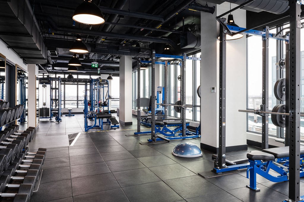 a workout room with weights and cardio equipment in a gym