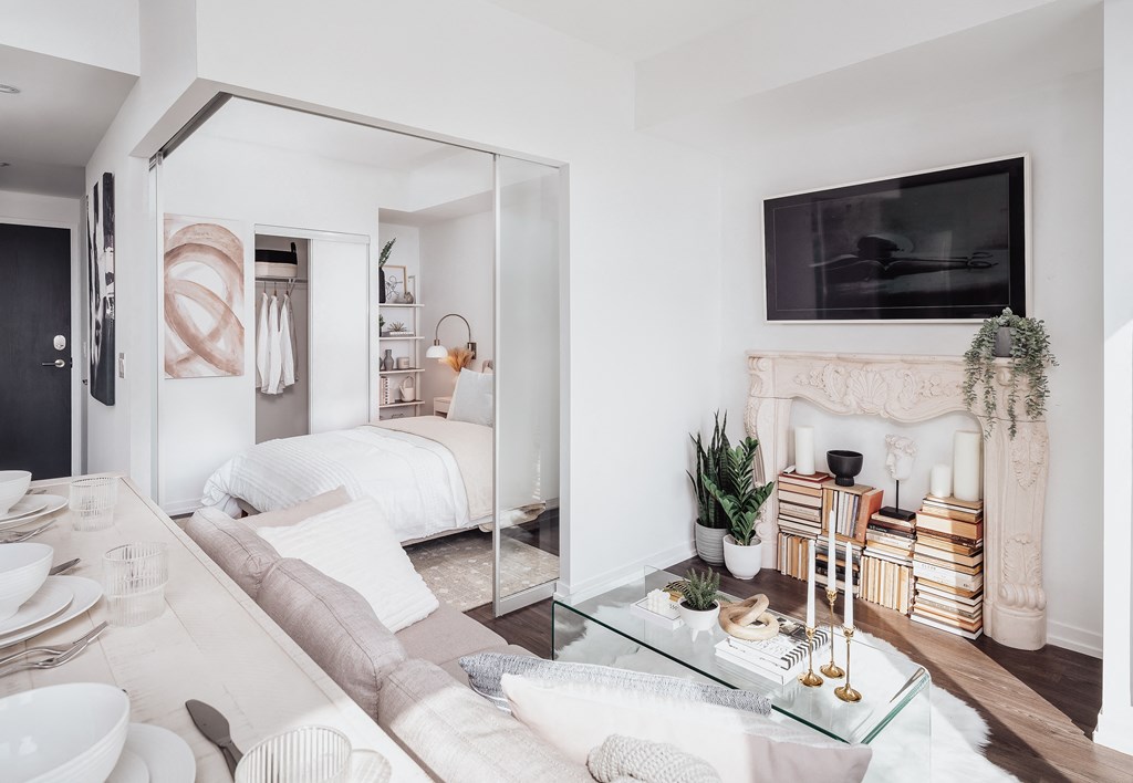 a living room with a couch and a table and a bedroom with a bed