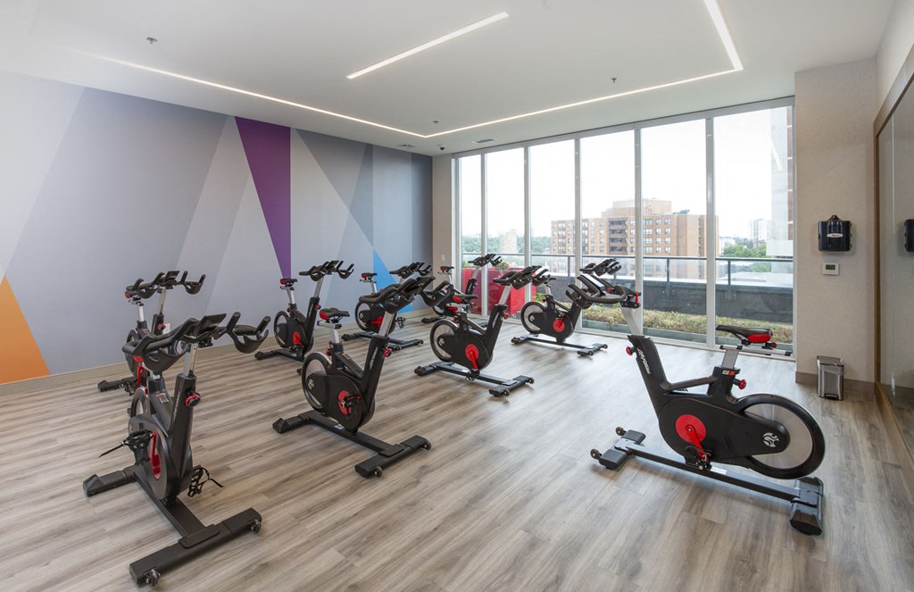 a spin class room with exercise bikes in front of a wall of windows