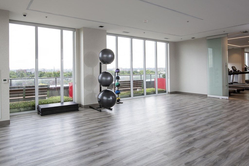 a large room with floor to ceiling windows and a yoga room with spheres in it
