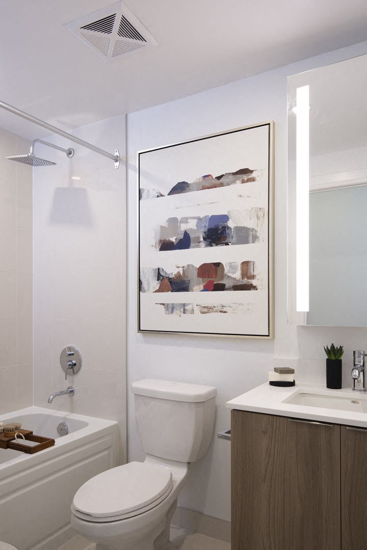 a bathroom with a white toilet and a picture on the wall