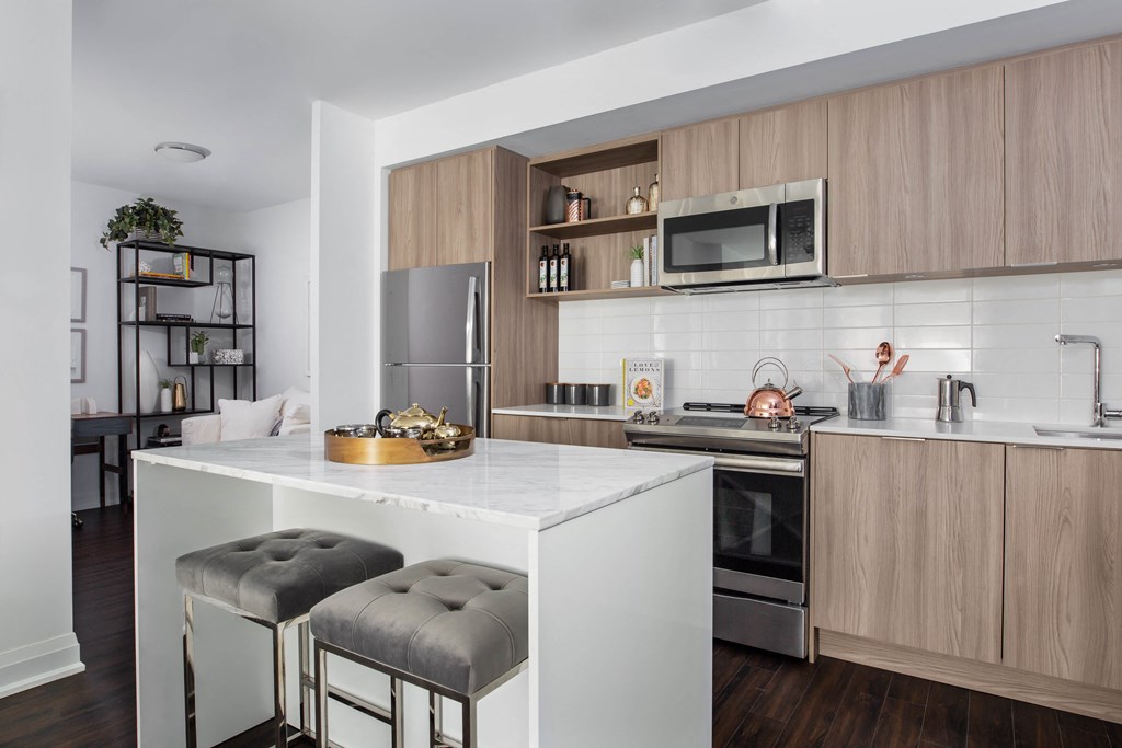 a kitchen with wooden cabinets and a white island with two stools