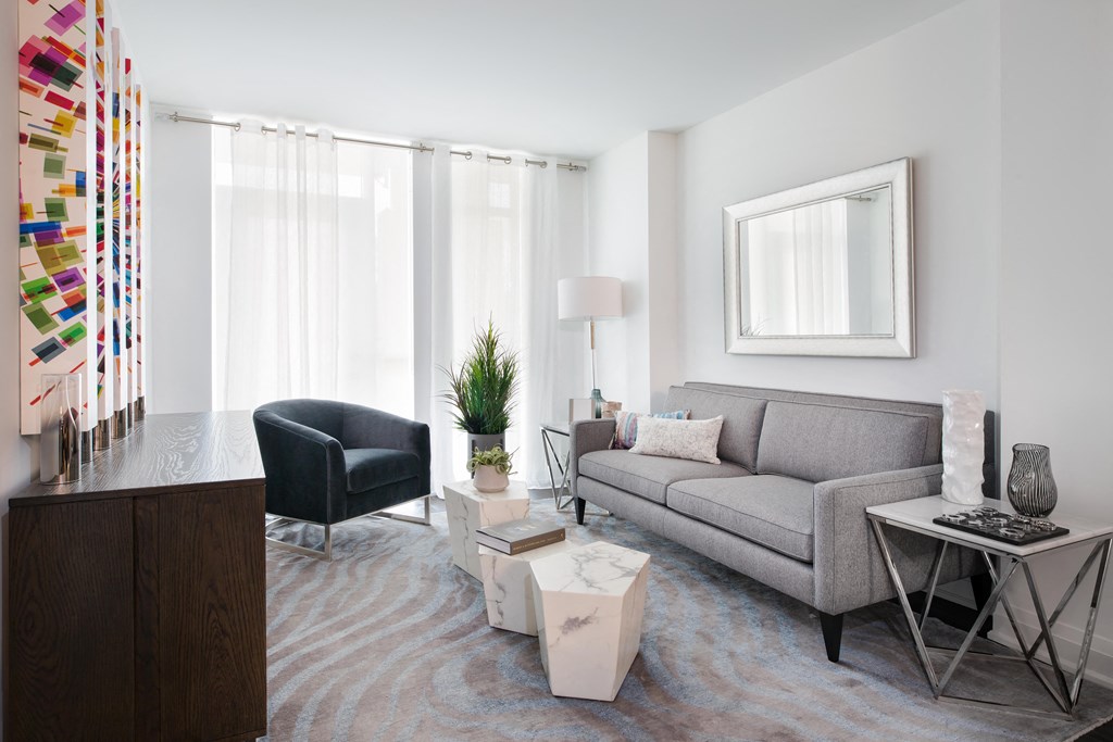 a living room with a gray couch and a black chair