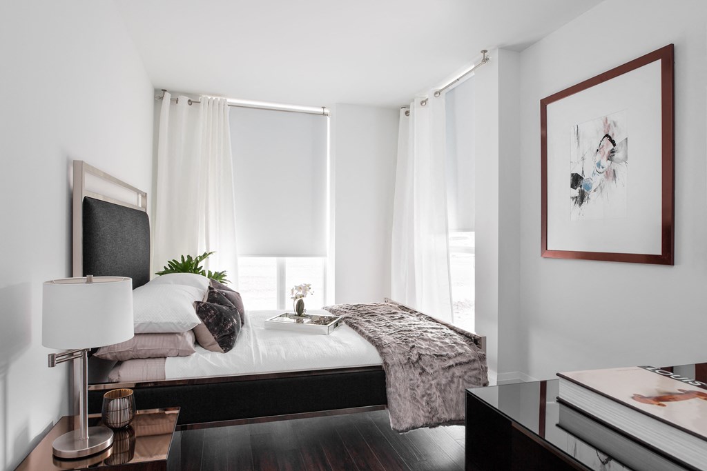 a bedroom with white walls and a bed with pillows and a blanket