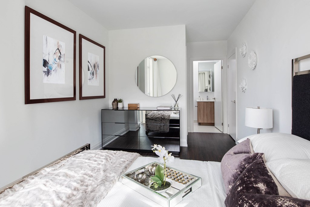 a bedroom with a bed and a mirror on the wall