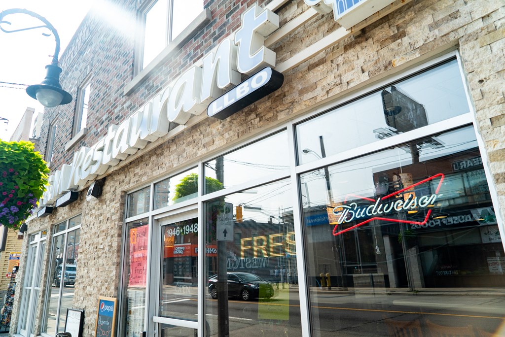 the front of a building with a bud light sign in the window