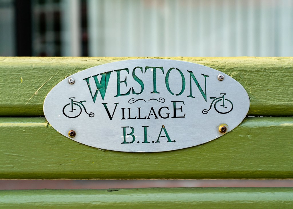 a sign on a green bench that reads bla