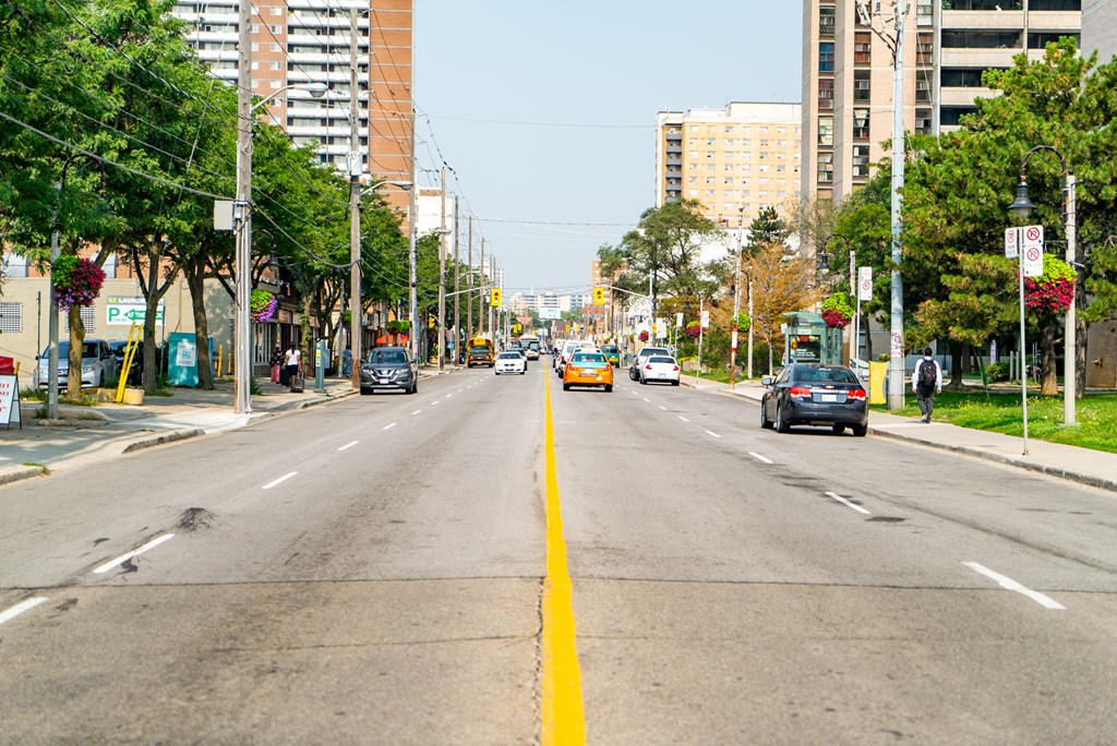 a city street with cars driving down it and buildings on both sides of the road