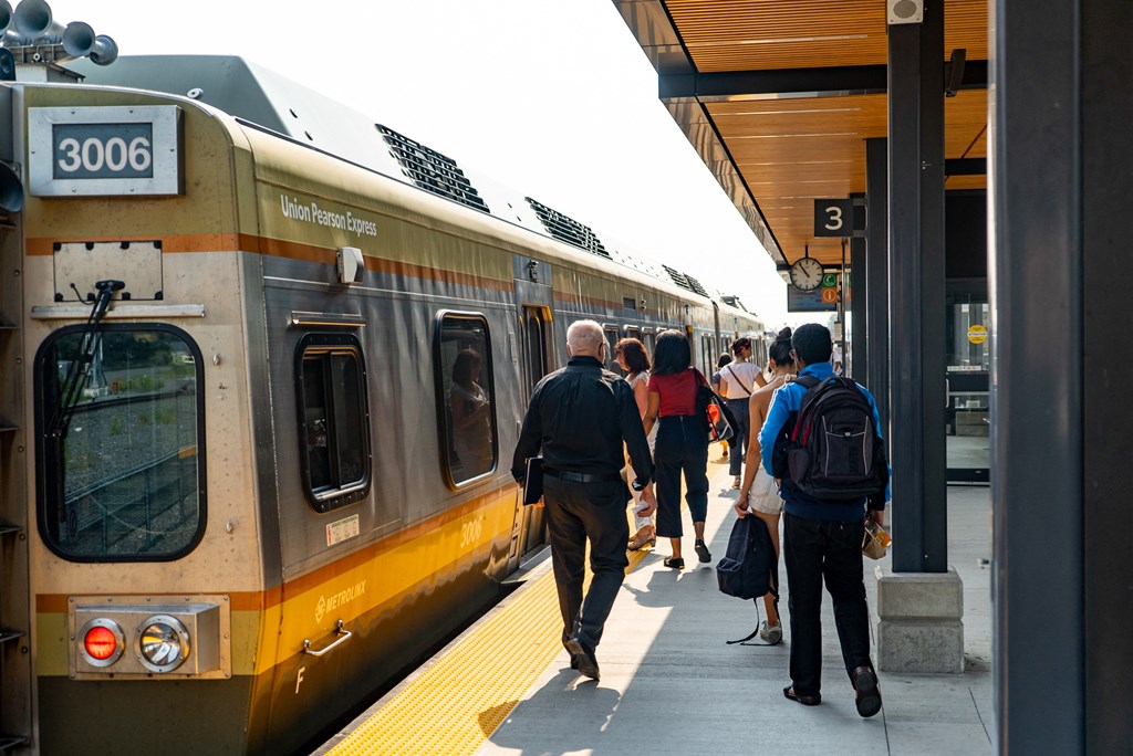 people waiting to board a train at a train station