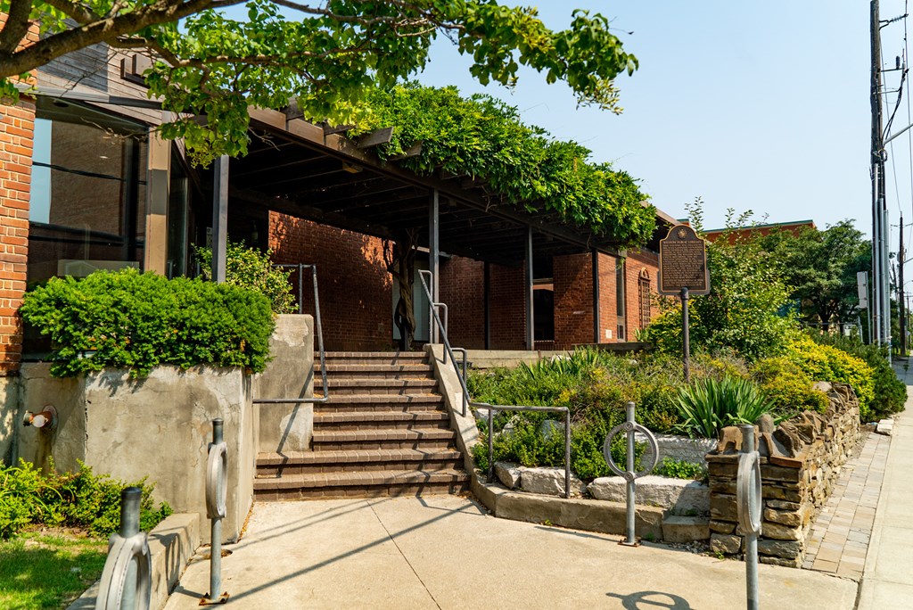 the outside of a building with stairs and plants