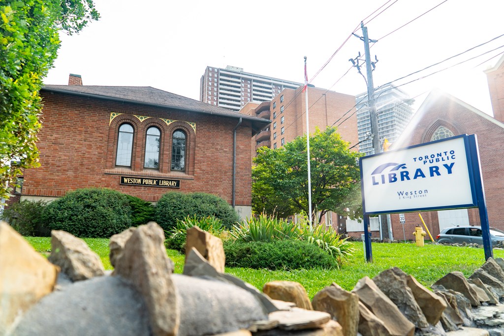 an old brick building with a library sign in front of it