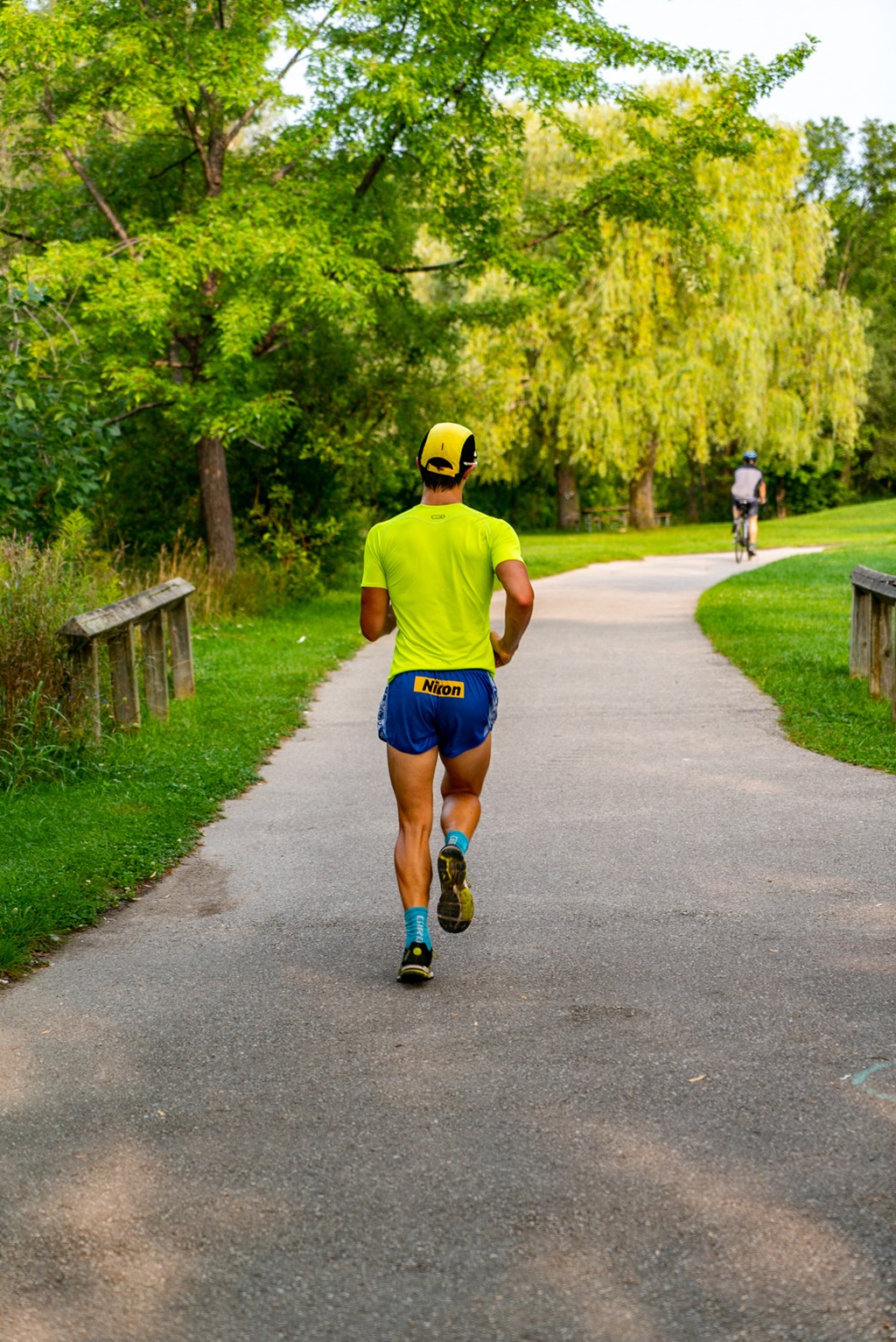 a man running down a road in a park