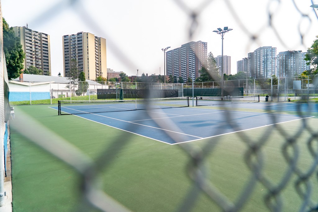 a tennis court with a city skyline in the background