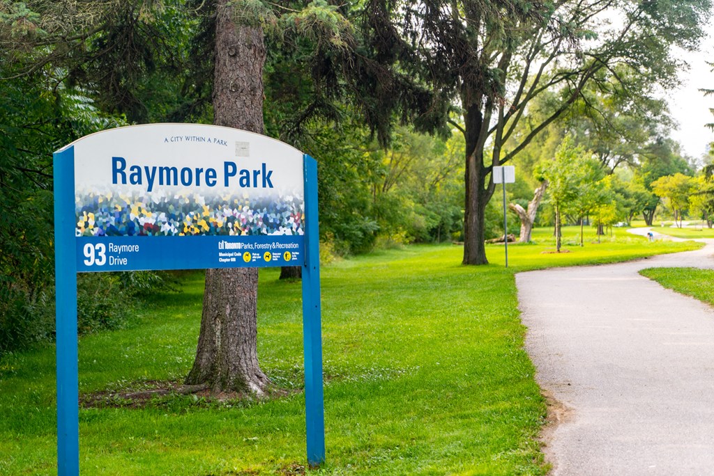 a sign in front of a path and trees