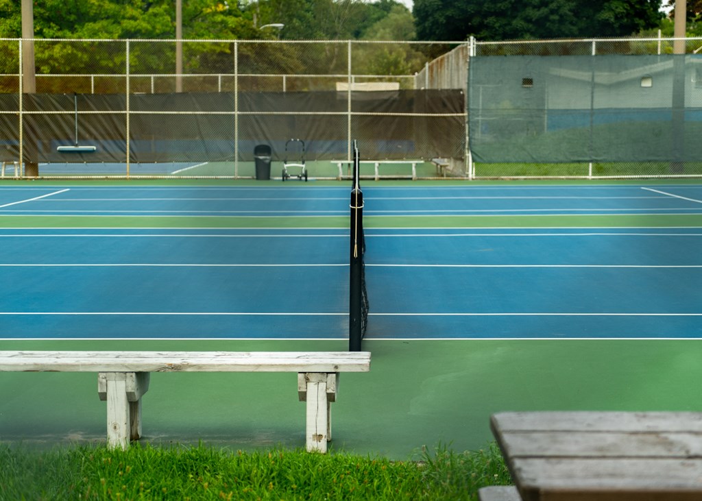 a tennis court with a bench in front of it