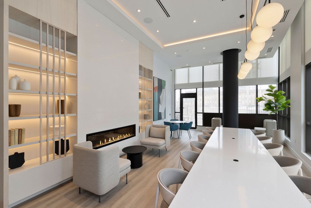 A modern living room with a fireplace and a long white table.
