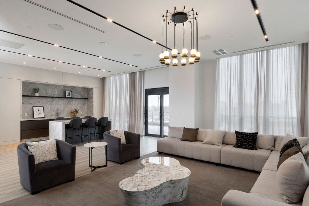 A modern living room with a marble coffee table and a chandelier.