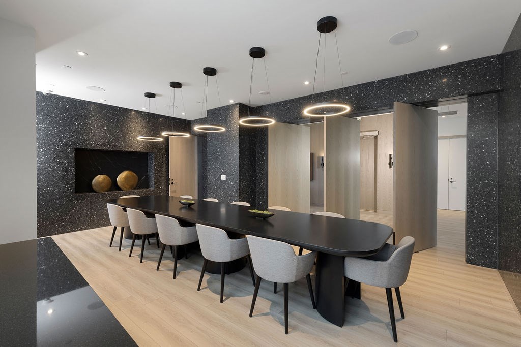 A modern dining room with a black table and chairs.
