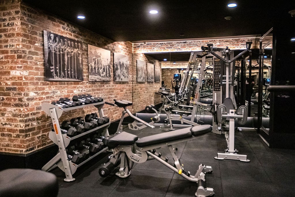 a gym with weights and other exercise equipment on a brick wall