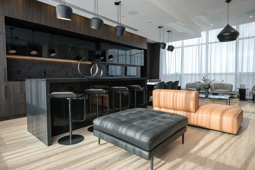 a living room with a couch and a bar with chairs