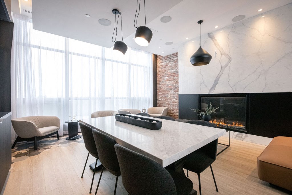 a dining room with a marble table and chairs and a fireplace
